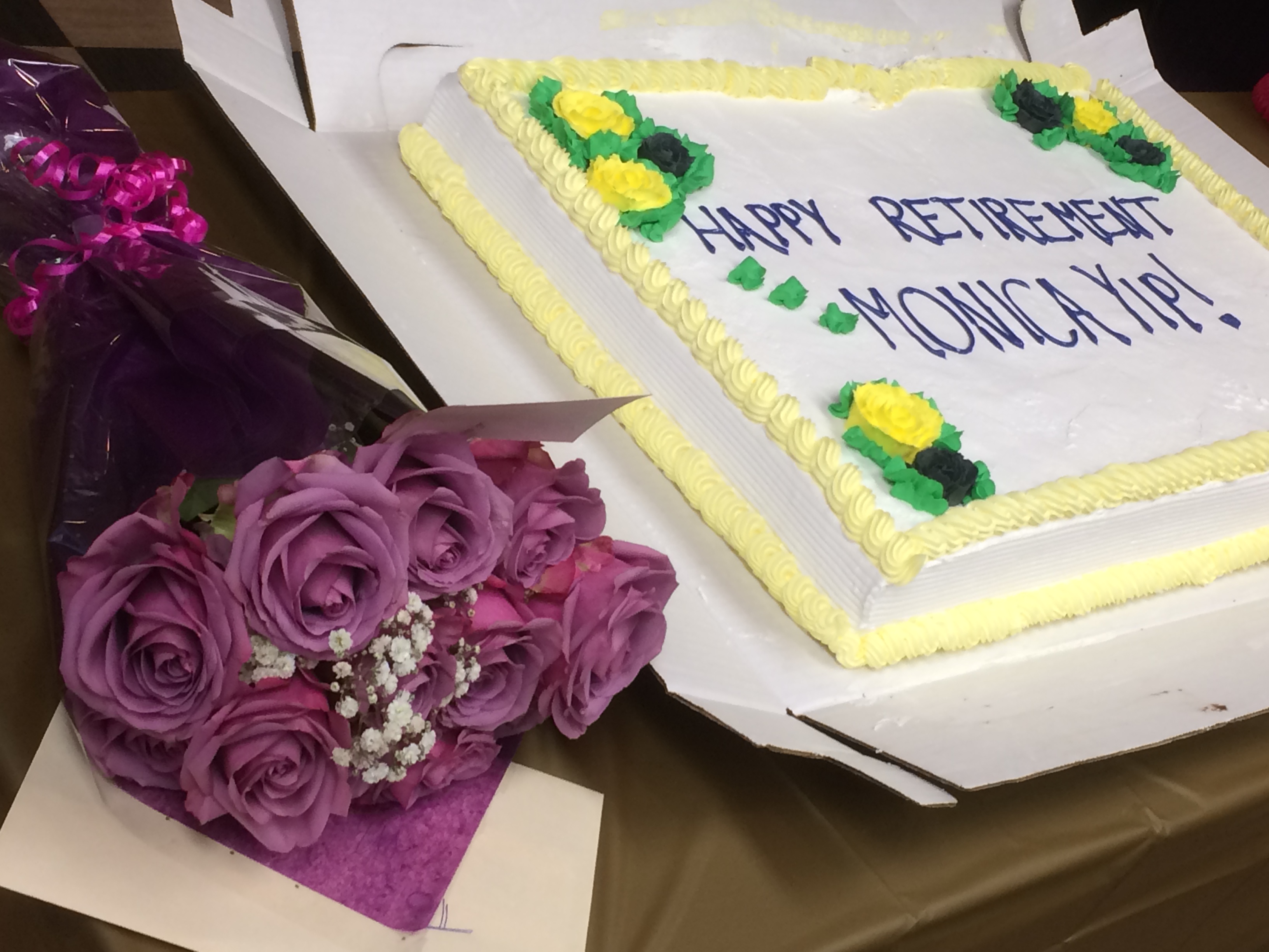 M姐姐退休派对上的蛋糕和花束，蛋糕上写着 Happy Retirement Monica Yip。