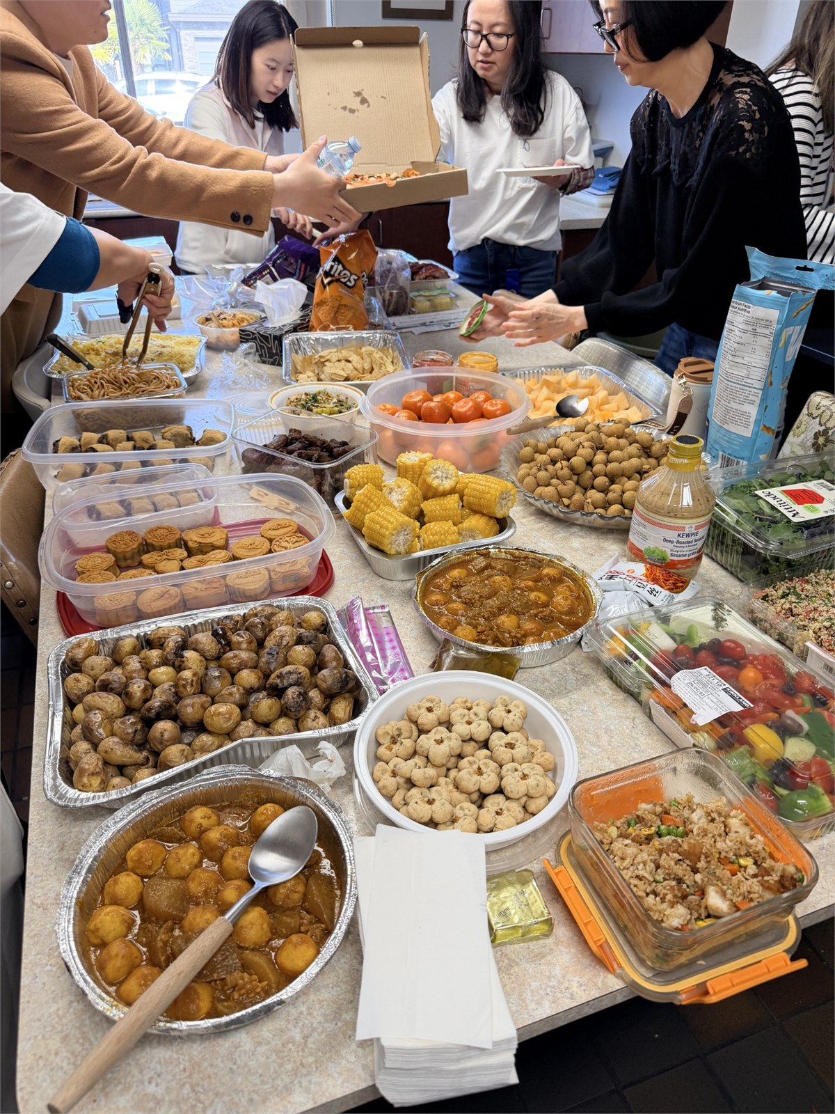 中秋聚会的餐桌上摆满大家分享的食物。