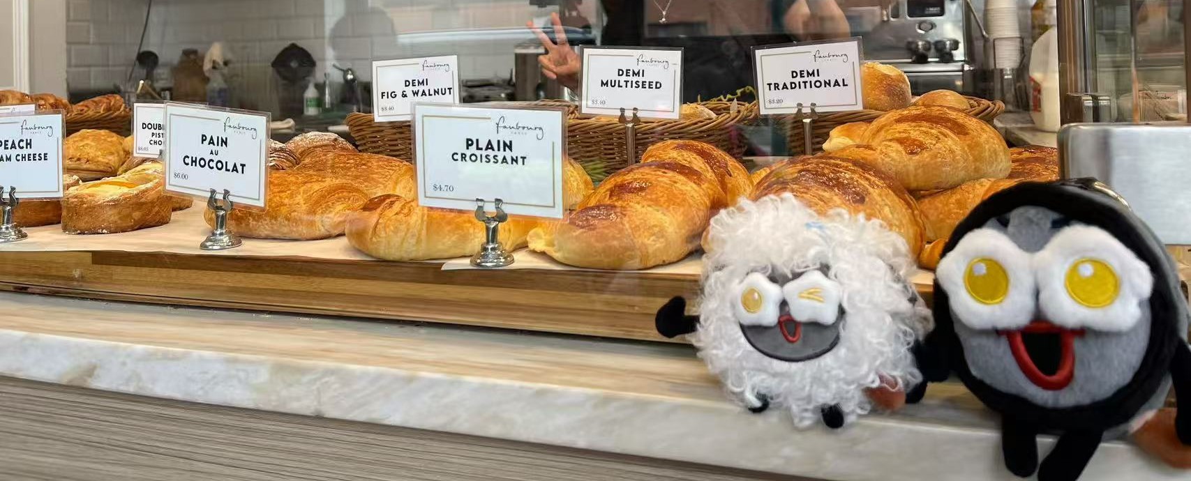咖啡店展示柜前的点心和两个生米玩偶。