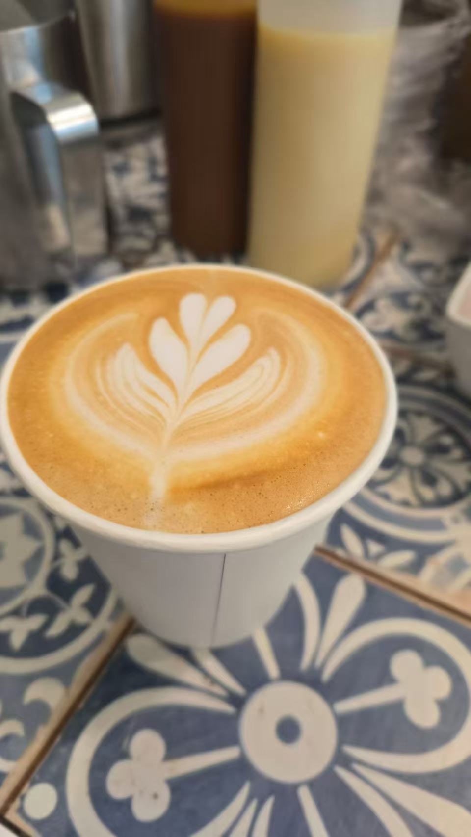 一杯带有叶子形状拉花的咖啡。